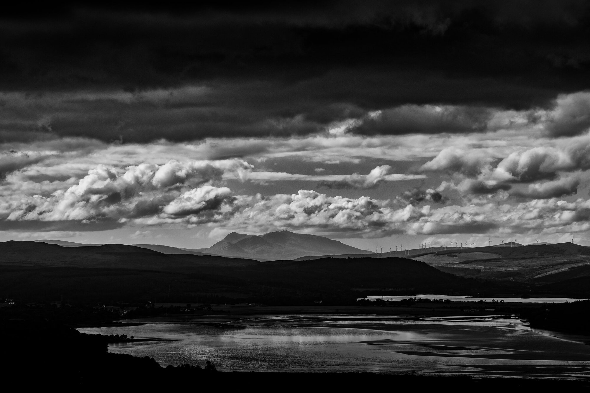 Bright clouds over a lochan and the moor