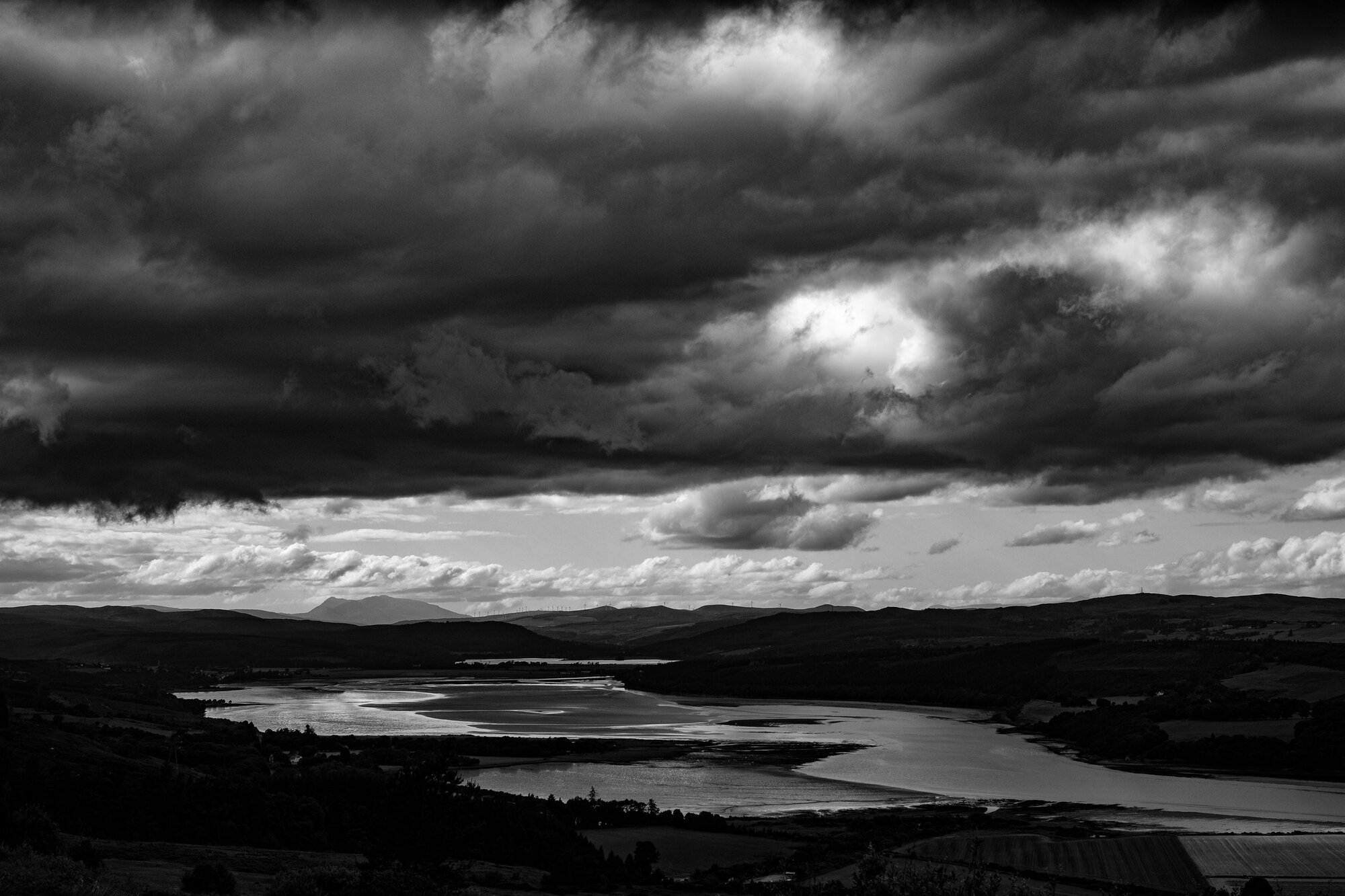A sky of heaped cloud over winding lochs and moorland