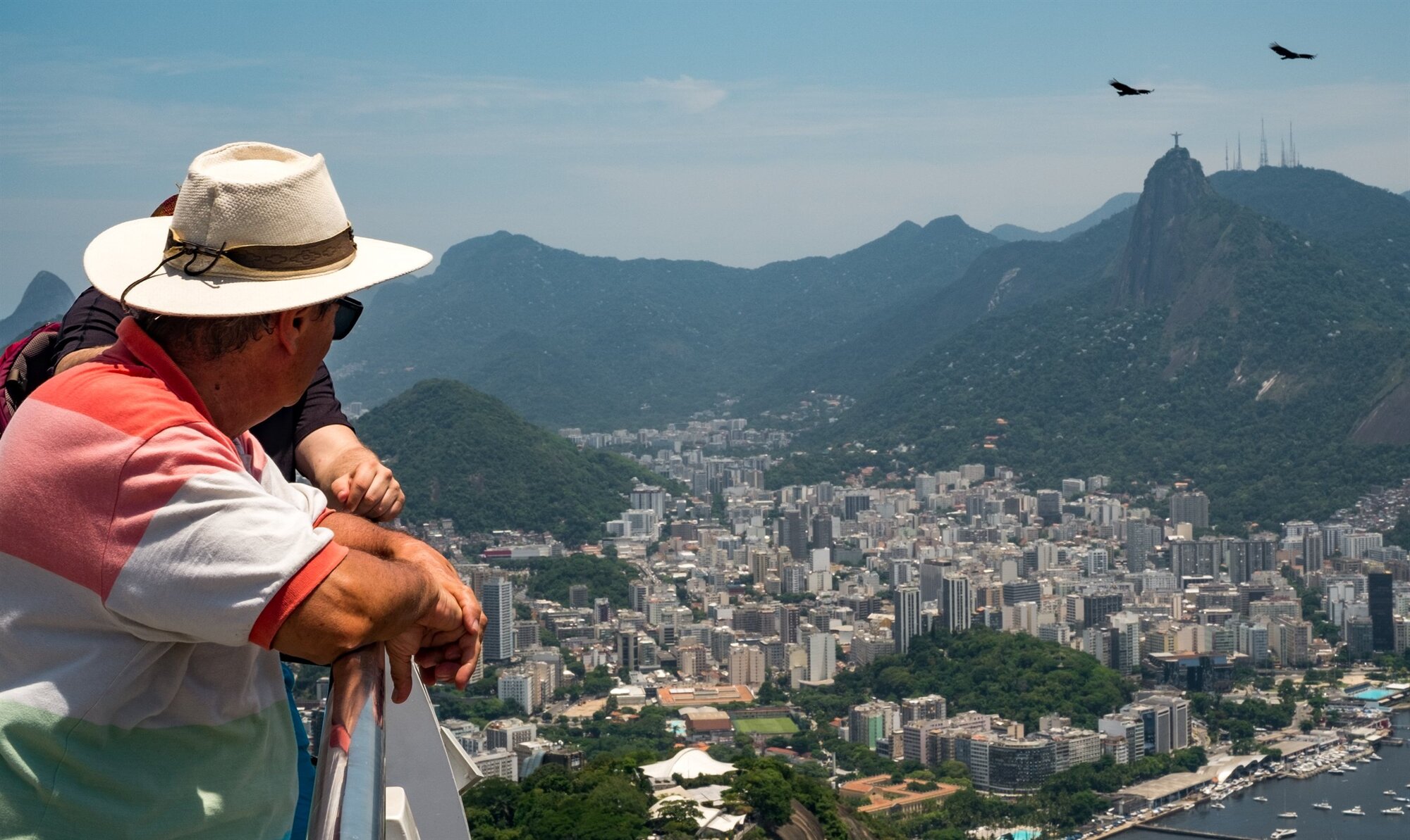 A man in a hat looking out over Rio towards Christ the Redeemer