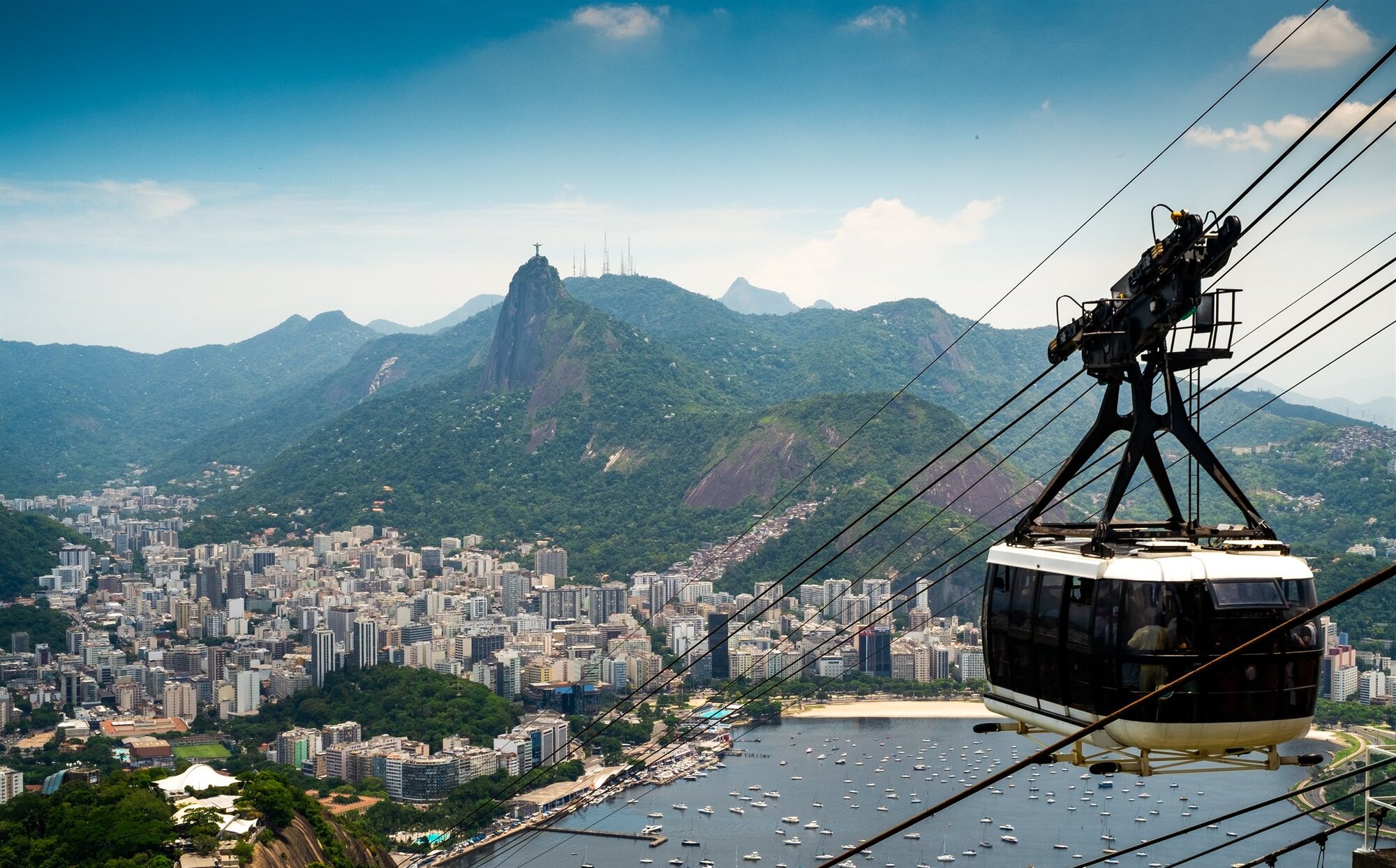 A cable car above Rio, Christ the Redeemer on the mountain beyond
