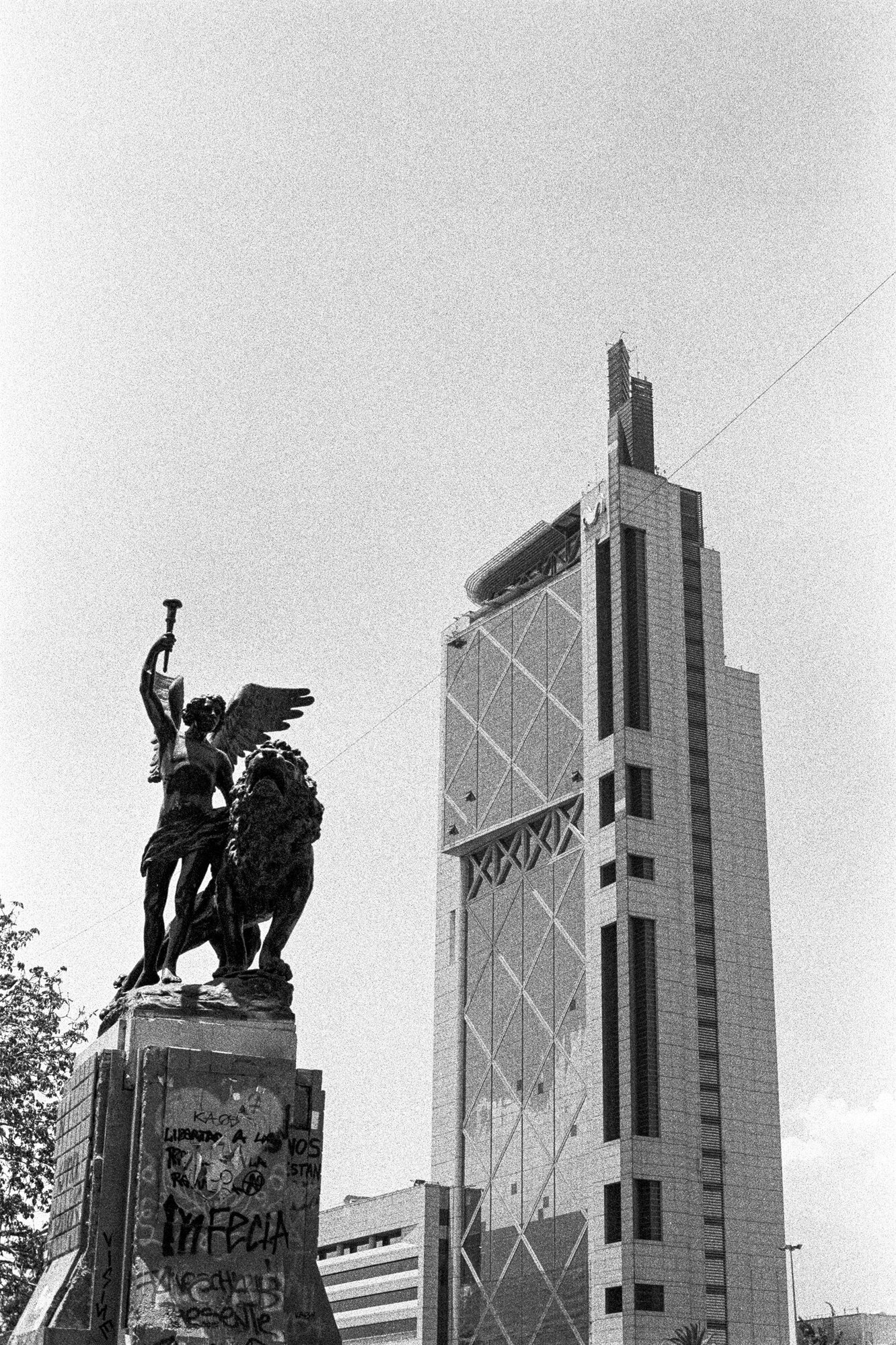 A statue before a tall tower in Santiago