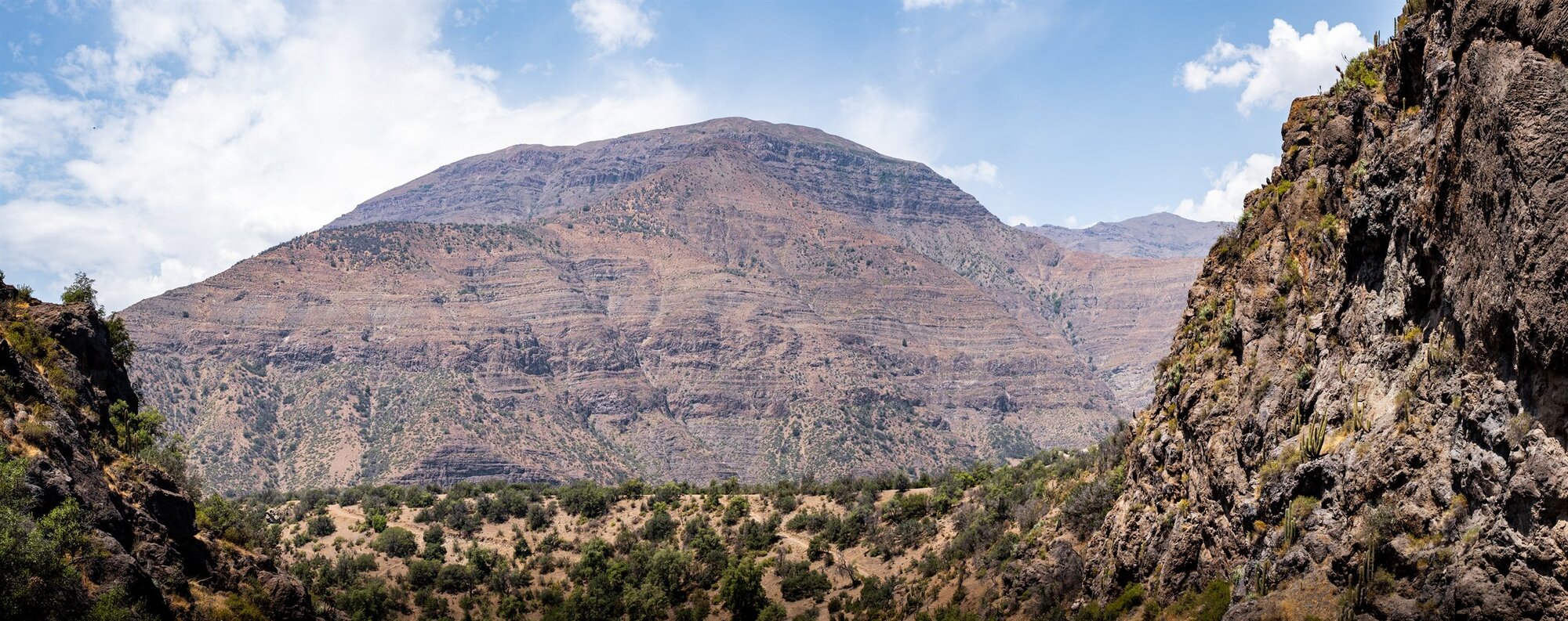 A red mountain rising beyond a canyon wall