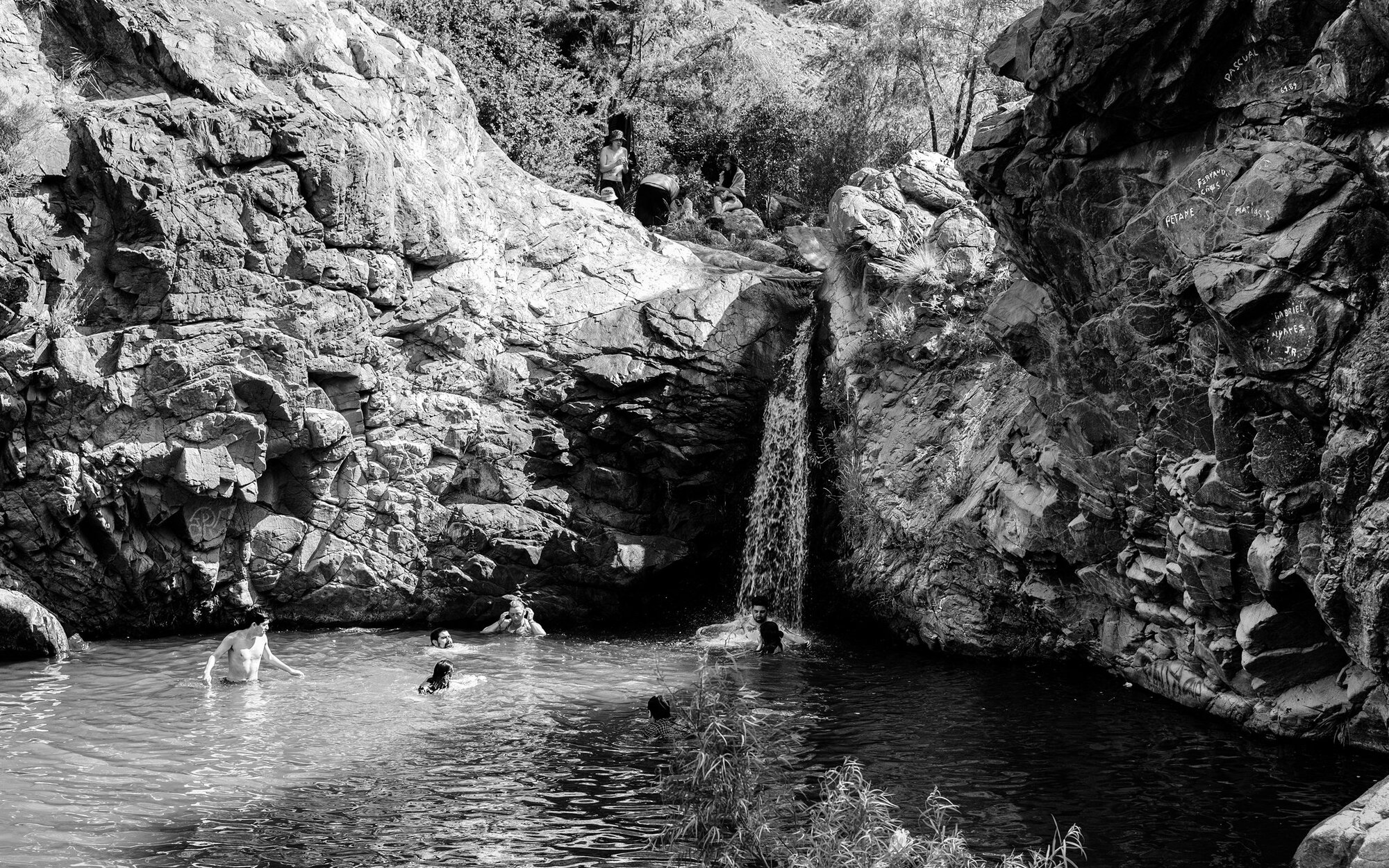 A waterfall falling into a pool in a rocky canyon